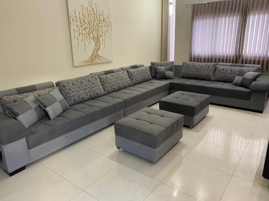 Reforma de sofá retrátil cinza realizada pela Magnífico Estofados na Barra da Tijuca, Rio de Janeiro. Imagem detalhando o acabamento impecável em ambiente moderno, ideal para serviços de estofador profissional e renovação de estofados de luxo.